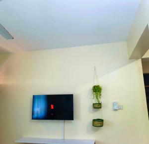 a flat screen tv hanging on a white wall at Meyer Stays in Kilifi