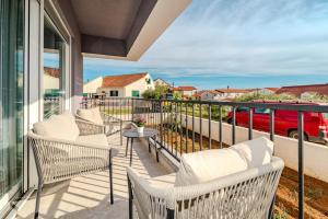 a balcony with chairs and a table with a view at Apartment Anna - free private parking in Zadar