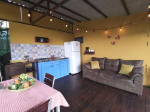a kitchen and living room with a couch and a table at The Dreamcatcher House Glamping & Cabins Sarchí in Sarchí