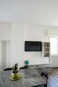 a living room with a table and a tv on a wall at Arlu lake house Lazise in Lazise +13 photos