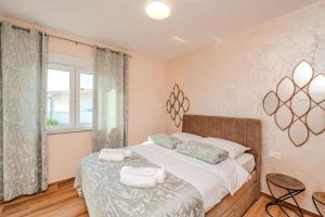 a bedroom with a bed with two towels on it at Apartment Anna - free private parking in Zadar