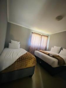a bedroom with two beds and a window at Number 8 in Maseru