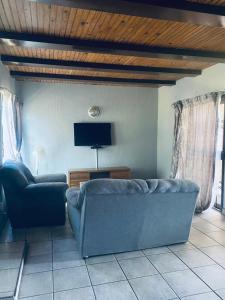 a living room with a blue couch and a tv at Number 8 in Maseru