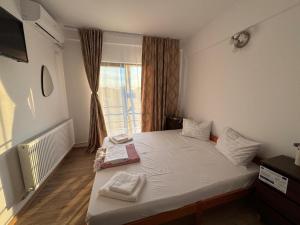 a small bedroom with a bed with a window at Pensiunea SAUVAGE in Corbu