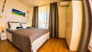a bedroom with a bed and a large window at William's apartments - second cozy studio in Sveti Vlas