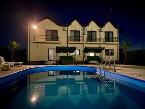 a house with a swimming pool at night at Pensiunea SAUVAGE in Corbu