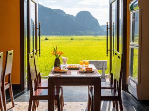 a table and chairs with a view of a field at Tam Coc Haven House in Ninh Binh