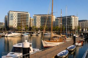 a group of boats docked in a marina with buildings at CK Serviced Apartments, Titanic Quarter, Belfast in Belfast