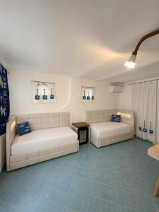 two white couches in a room with blue tiles at Piccolo Hotel Luisa in Ponza +133 photos
