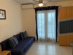 a living room with a blue couch and a window at Apartments Rubis in Rovanjska
