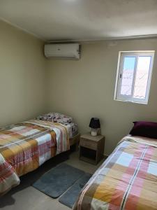 a bedroom with two beds and a window at Sucasa Apartment B in Willemstad