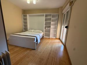 a bedroom with a bed and open shelving at Spiranca Cityview Residence in Tirana