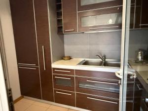 a kitchen with wooden cabinets and a sink at Spiranca Cityview Residence in Tirana