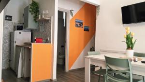 a kitchen and dining room with an orange wall at La Casetta al Poggio in Valentano