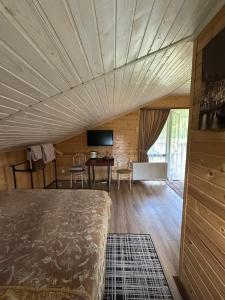 a bedroom with a bed and a table and a television at Гостинний двір Підкова in Budishche