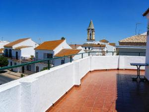 a balcony with a white fence and a clock tower at Hostal Muriel in Aljaraque