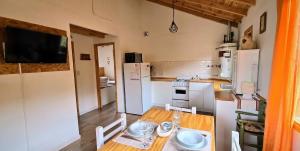 a kitchen with a wooden table and a white refrigerator at Cabaña Meely in El Calafate +31 photos