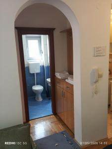 an archway leading into a bathroom with a toilet at Apartment Grandis in Škaljari +5 photos
