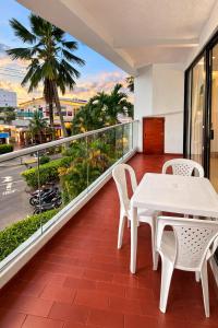 a white table and chairs on a balcony with a view at Al Reef Apartamentos TOP in San Andrés