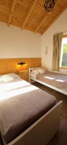 a bedroom with two beds and a window at Cabaña Meely in El Calafate