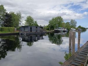 a house on a dock on a river at Houseboat Enjoy with 200m Private Garden on the Lake in Vinkeveen