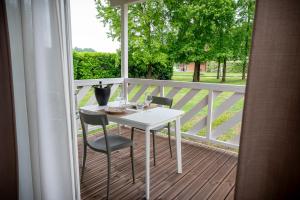 a white table and chairs on a wooden deck at Agriturismo Tenuta "Il Cigno" in Villanterio