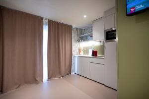 a kitchen with white cabinets and a window with a television at Agriturismo Tenuta "Il Cigno" in Villanterio