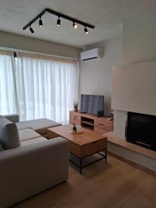 a living room with a couch and a flat screen tv at Stones villa corfu in Varypatádes