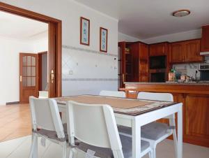 a kitchen with a table and white chairs at Great for Families in Lourinhã-Double Rooms-Private Baths-Free Parking & Extra Bed in Lourinhã