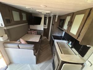 an interior view of an rv with a couch and a table at Rocking Horse Stables in Altoona +1 photo