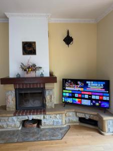 a living room with a fireplace and a flat screen tv at Pokoje Ella in Jelenia Góra
