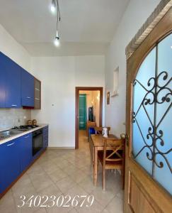 a kitchen and dining room with a table and blue cabinets at Casa Vacanze Torre di Mola in Formia +19 photos