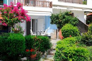 a garden with flowers and plants in front of a house at FILIPPIDIS suites in Neos Marmaras