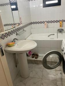 a bathroom with a sink and a toilet and a tub at Beau Rez de Jardin in Ariana