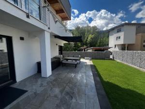 a patio with a bench in the backyard of a house at Alpinelodge8 in Innsbruck
