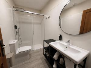 a bathroom with a sink and a toilet and a mirror at CASA DAS XACIAS, RIBEIRA SACRA in A Airoa +16 photos