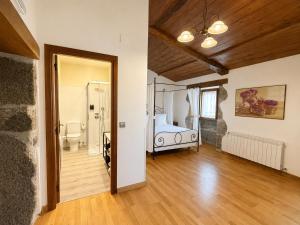 a bedroom with a bed and a bathroom at CASA DAS XACIAS, RIBEIRA SACRA in A Airoa