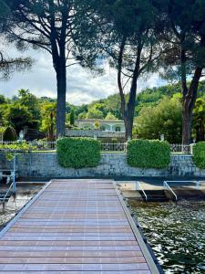 a walkway in a park with trees and a building at Casa Blanca - Villa with pool and private beach in Lesa