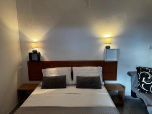a bed in a room with two lights on the wall at Apartments Rubis in Rovanjska