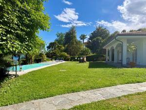 a house with a yard with a swimming pool at Casa Blanca - Villa with pool and private beach in Lesa
