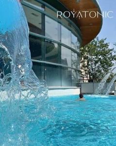 a fountain in the water in front of a building at Petit cocon près des grottes de Perrier in Perrier