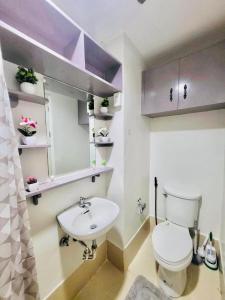 a bathroom with a white toilet and a sink at The Loop Towers Limketkai in Pontud