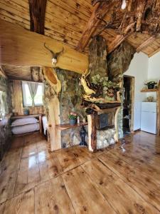 a living room with a stone fireplace in a cabin at Cabana Noah Rustic in Vîlcăneşti +28 photos