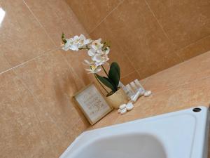 a bathroom with a toilet and a book and flowers at Vila Adina in Eforie Nord +37 photos