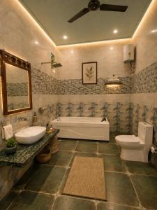 a bathroom with a tub and a sink and a toilet at Agastya Vilas Resort in Dhandni