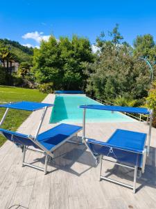 a swimming pool with two chairs and a table at Casa Blanca - Villa with pool and private beach in Lesa