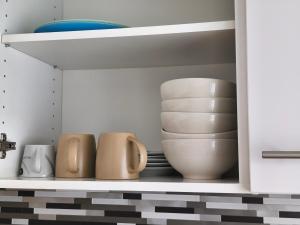 a cupboard with plates and bowls and bowls at Monteurunterkunft nahe Münster in Drensteinfurt +12 photos