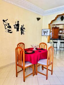 a dining room table with a red table cloth on it at Vintage apartment EL JADIDA in El Jadida