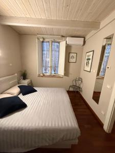 a bedroom with a large white bed and two windows at Martina Fillungo Loft in Lucca