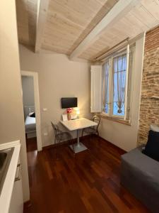a small living room with a table and a bed at Martina Fillungo Loft in Lucca